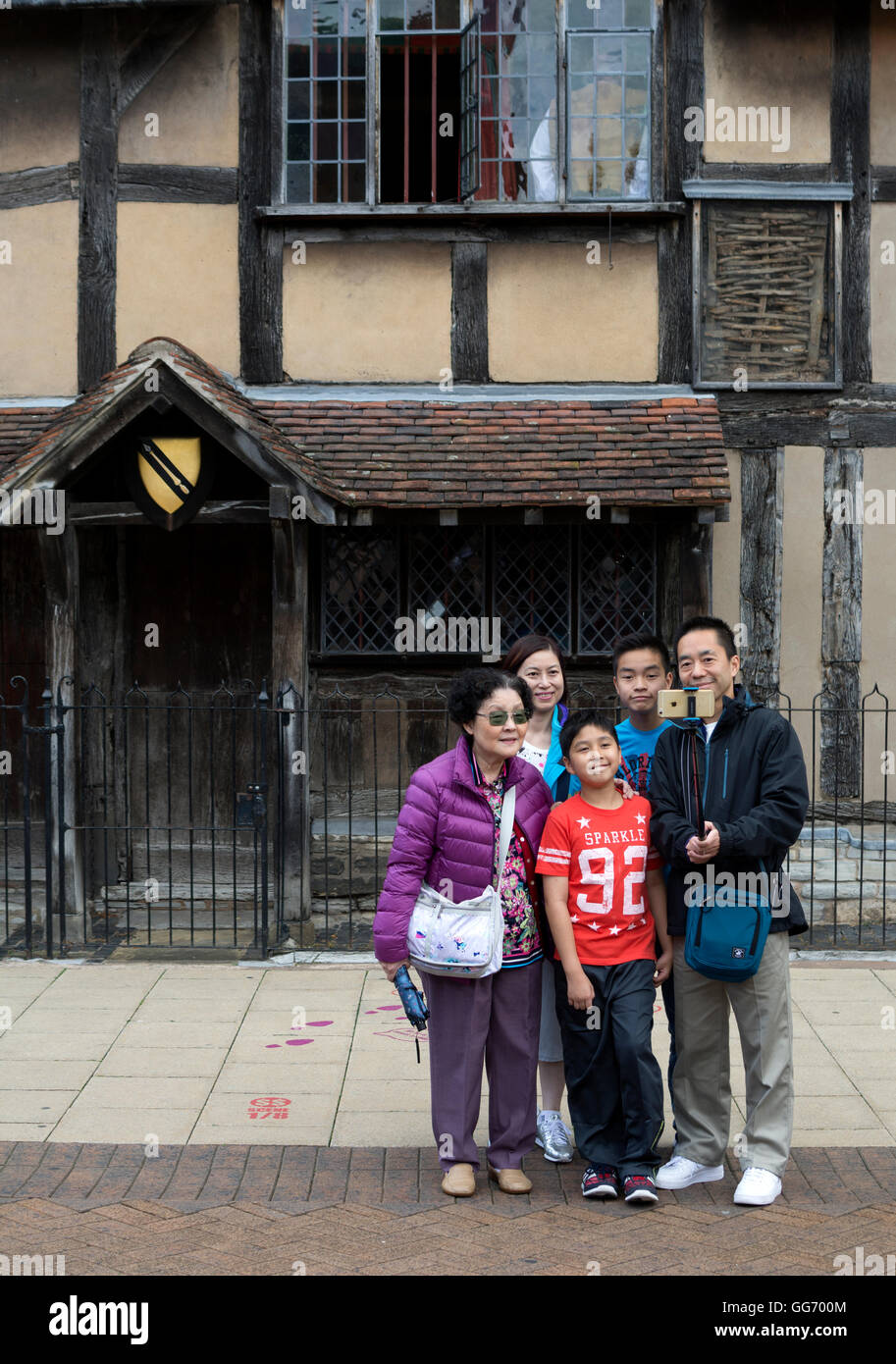 Chinese tourists taking selfie photograph outside William Shakespeare`s Birthplace, Stratford-upon-Avon, Warwickshire, UK Stock Photo